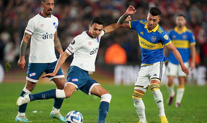 Lucas Janson de Boca Juniors pelea el balon con Daniel Bocanegra de Nacional