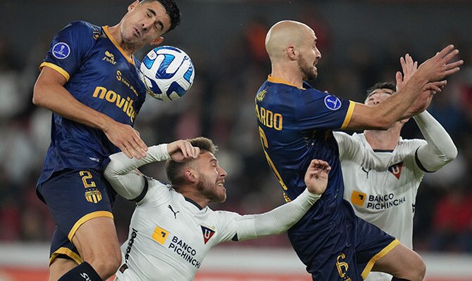 Jugadores de LDU Quito en disputa del balon en partido contra Magallanes