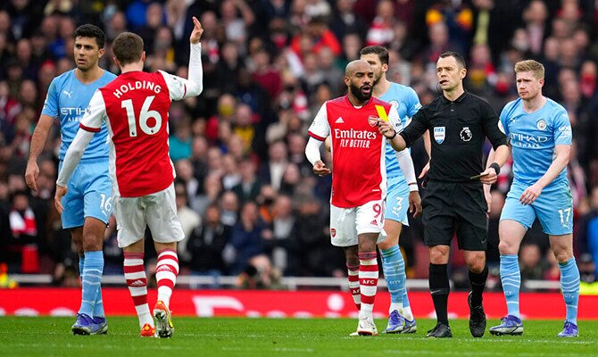 Rob Holding del Arsenal recibe una tarjeta amarilla ante el Manchester City