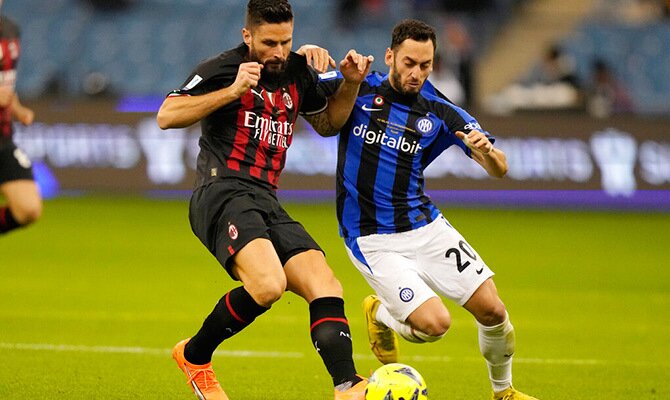 Olivier Giroud del Milan y Hakan Calhanoglu del Inter en disputa