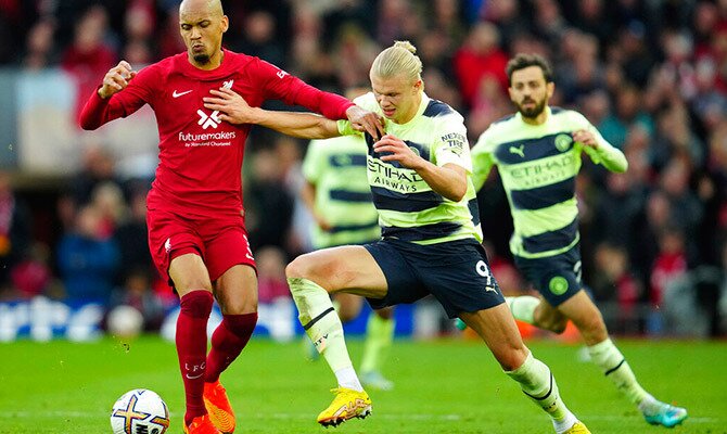 Fabinho del Liverpool y Erling Haaland del Man City en busca del balon