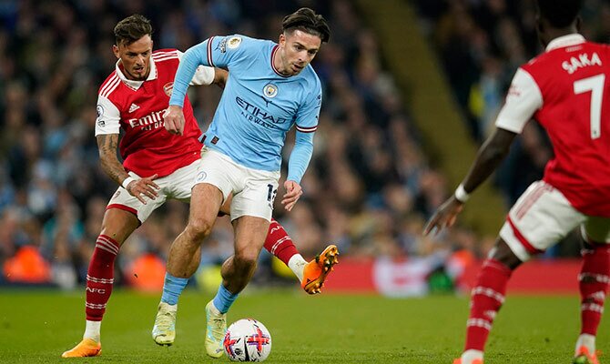 Ben White y Jack Grealish disputan el balon en el duelo entre Man City y Arsenal