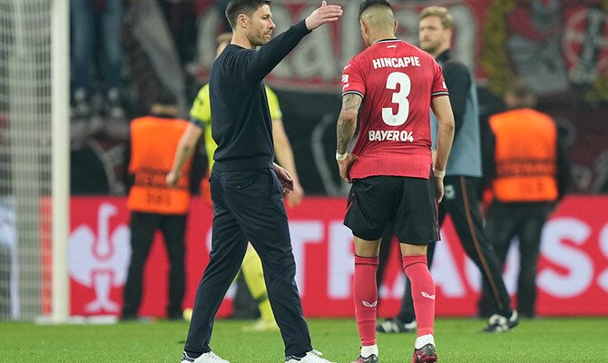 Piero Hincapie recibe el saludo de Xabi Alonso en partido del Leverkusen