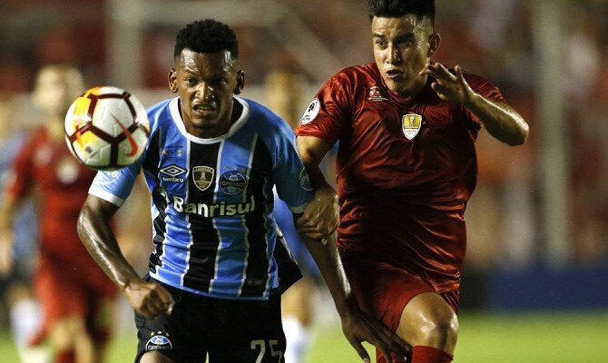 Jugadores de Gremio e Indpeendiente corren por un balón. Conoce los pronósticos del Gremio Vs Independiente.