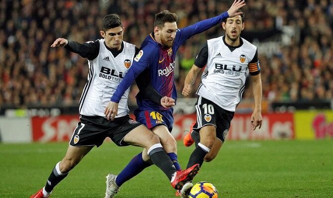 Messi (centro) trata de esquivar una entrada de Guedes. Conoce las cuotas del Barcelona Vs Valencia.