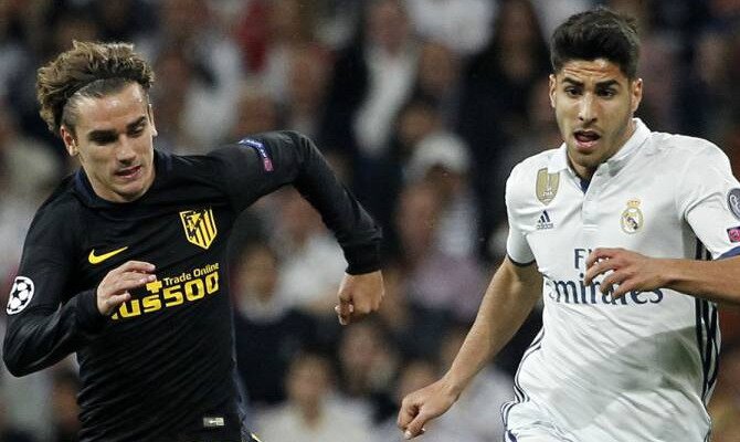 Griezmann (derecha) corre junto a Asensio en un derbi. Conoce las cuotas del Atlético de Madrid vs Real Madrid de LaLiga