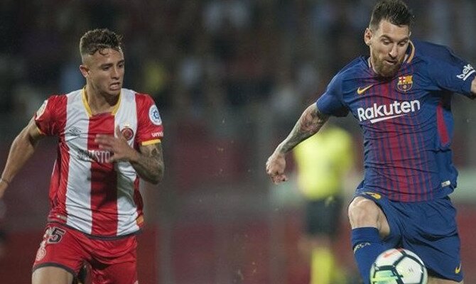 Messi (derecha) corre perseguido por un jugador del Girona. Conoce los pronósticos del Barcelona Vs Girona.