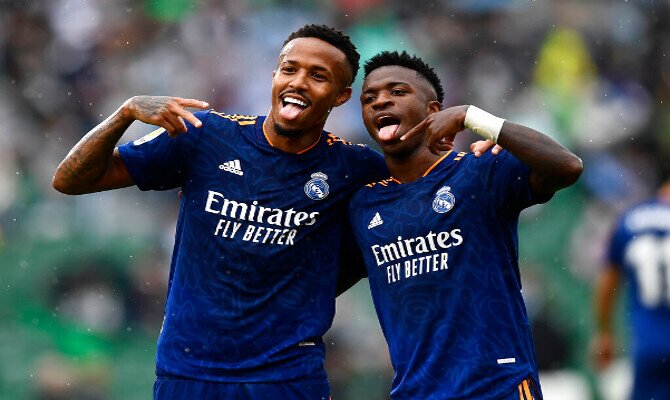 Vinicius y Militao celebran un gol. Picks para el Real Madrid vs Rayo Vallecano, LaLiga Santander.